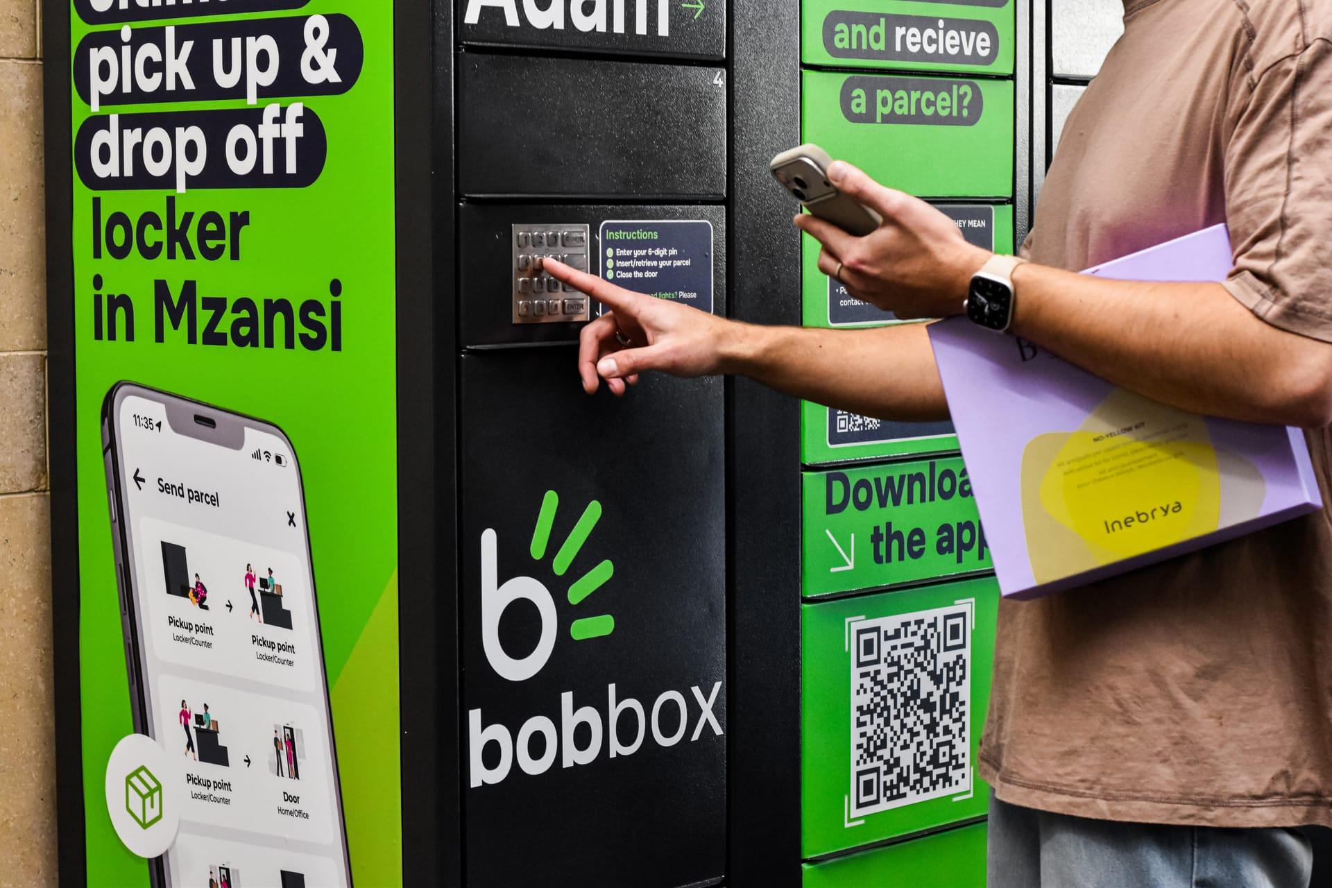A customer collects a parcel by entering their PIN at a Bob Box locker.
